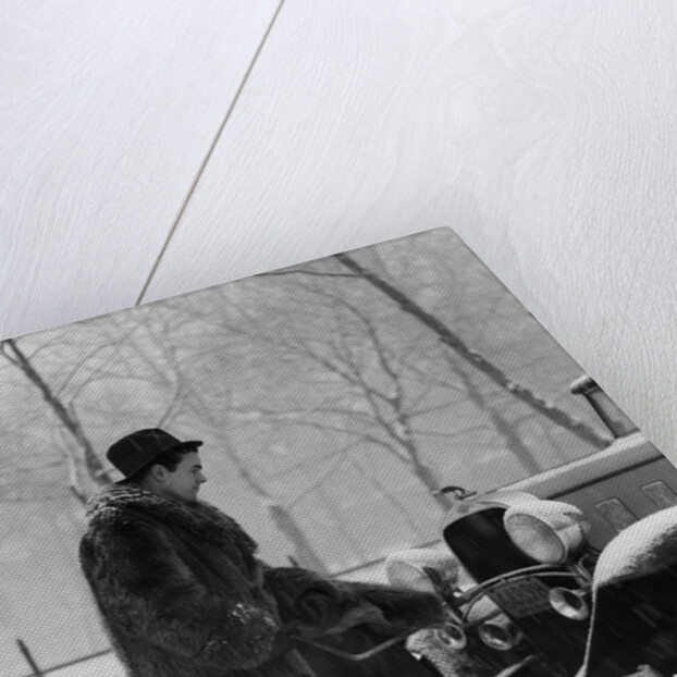 1930s Man In Hat And Raccoon Fur Coat Standing Foot On Bumper Of Chevrolet Roadster Stalled In Snow Storm by Anonymous