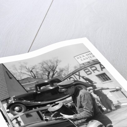 1930s Service Station Attendant In Cap and Coveralls Pouring Water From Spouted Can Into Automobile Radiator by Anonymous