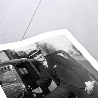 1930s Man In Suit And Hat Holding Gloves Stepping Into Automobile Driver Seat by Anonymous