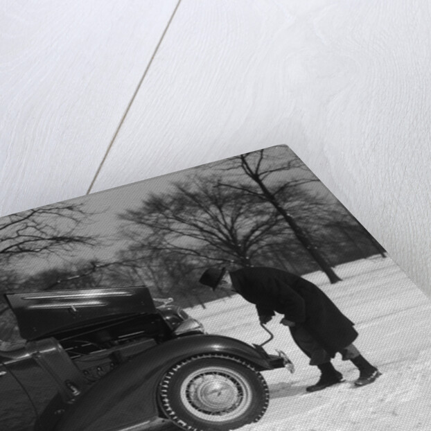 Woman Passenger Watching Man Motorist Try To Crank Start A Chevrolet Coupe Stalled In Snow by Anonymous