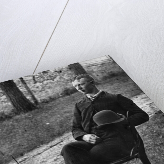 1890s 1900s Side View Of Man Wearing Suit Seated On Chair Outside Holding Bowler Hat by Anonymous