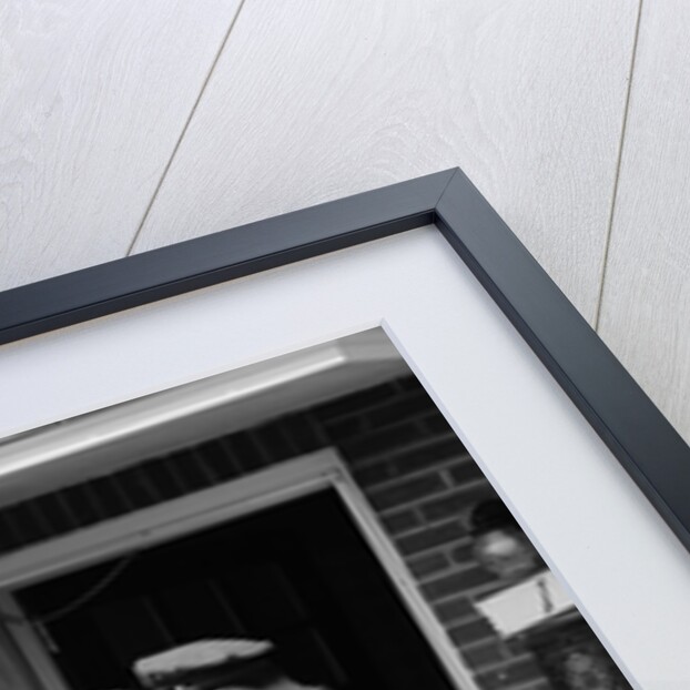1950s Suburban Mom At Home Front Door With Son Watching Receiving Package From Mailman by Anonymous