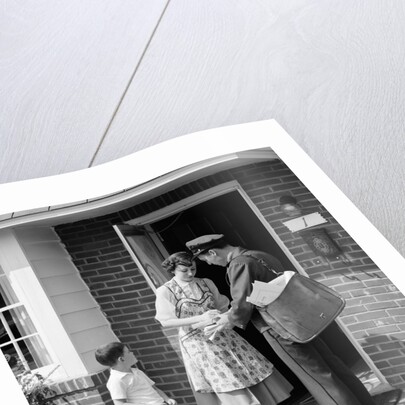1950s Suburban Mom At Home Front Door With Son Watching Receiving Package From Mailman by Anonymous