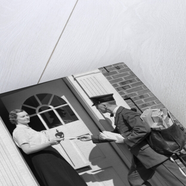 1930s Postman Giving A Letter To A Woman In The Doorway Of A Colonial Brick Home by Anonymous