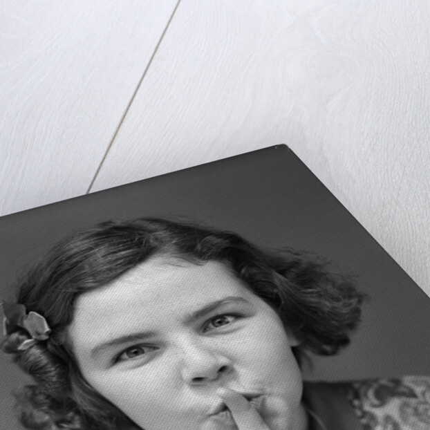 1930s Portrait Of Young Girl With Finger To Mouth Making Shush Be Quiet Expression by Anonymous