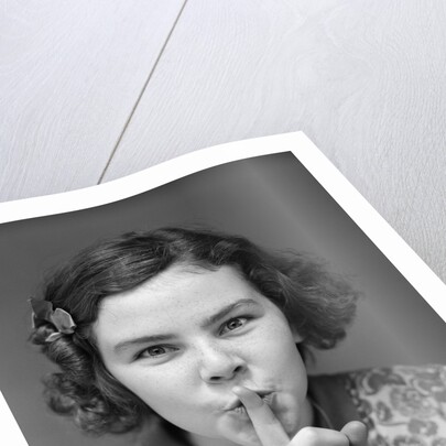 1930s Portrait Of Young Girl With Finger To Mouth Making Shush Be Quiet Expression by Anonymous
