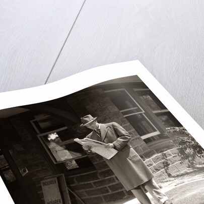 1950s Businessman On Railroad Station Platform Reading Newspaper Waiting For Train by Anonymous