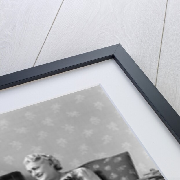 1940s Senior Couple Sitting In Living Room Reading Newspaper And Magazine Listening To Radio by Anonymous