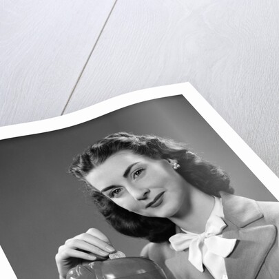 1940s Woman Putting Change Into Piggy Bank by Anonymous