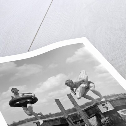 1940s 1950s Two Boys Wearing Inflatable Inner Tubes About To Jump In Lake Off Pier by Anonymous