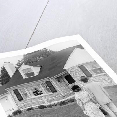 1940s 1950s Couple Standing Outside Looking At Stone Suburban House by Anonymous