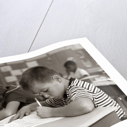 1960s Boy Striped T-Shirt Elementary School Classroom Sitting Desk Writing Test by Anonymous