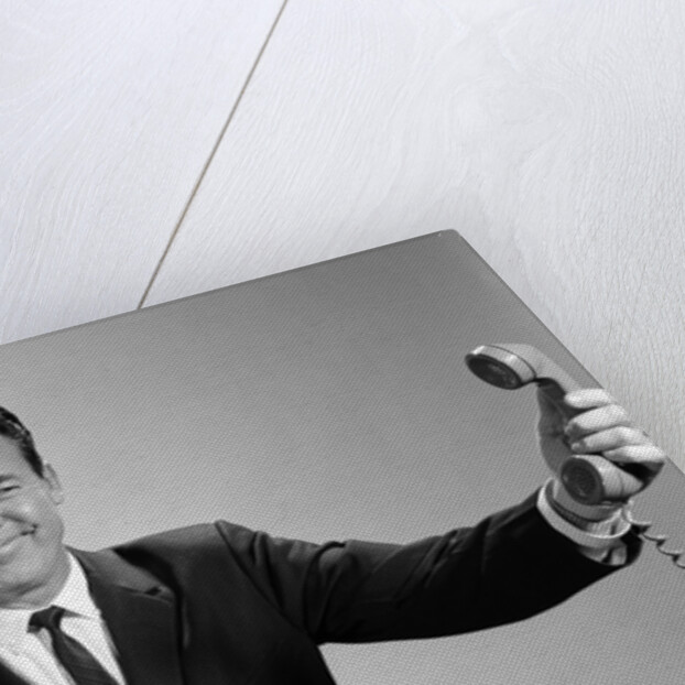 1960s Businessman Holding Telephone At Arms Length With Expression Of Disgust Or Rejection by Anonymous