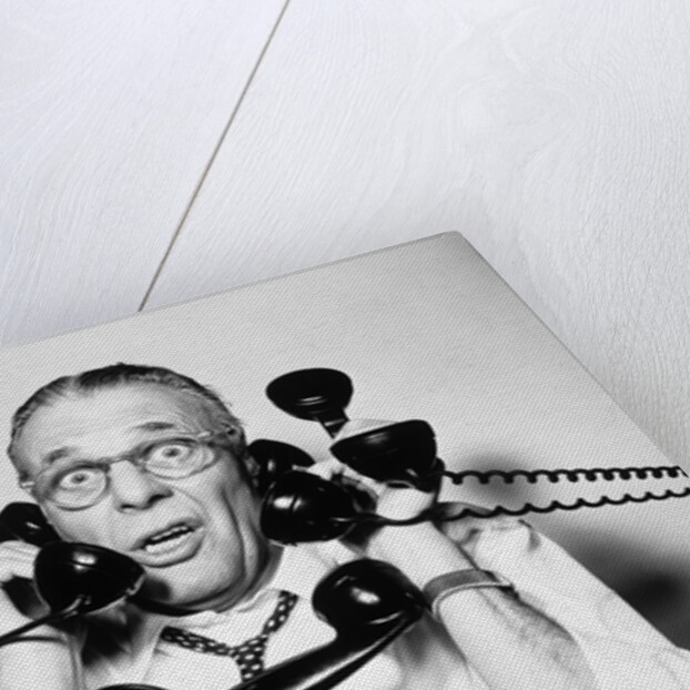 1950s 1960s Portrait Of Frazzled Businessman Trying To Answer Four Black Telephones Phones At Once by Anonymous