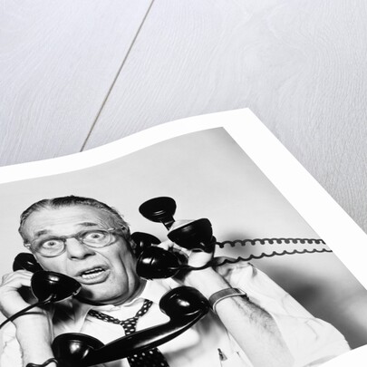 1950s 1960s Portrait Of Frazzled Businessman Trying To Answer Four Black Telephones Phones At Once by Anonymous