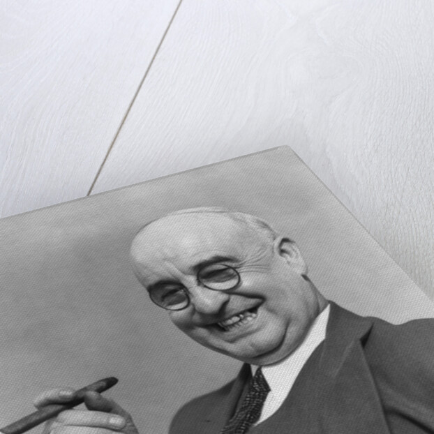 1930s Elderly Businessman In 3-Piece Suit and Glasses Leaning Back With Cigar In Hand by Anonymous