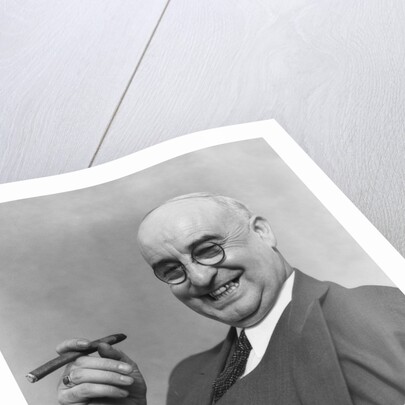 1930s Elderly Businessman In 3-Piece Suit and Glasses Leaning Back With Cigar In Hand by Anonymous