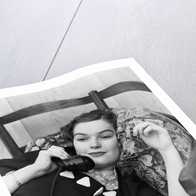 1930s Young Brunette Woman Reclining On Pillows Cigarette In Hand Talking On Telephone by Anonymous