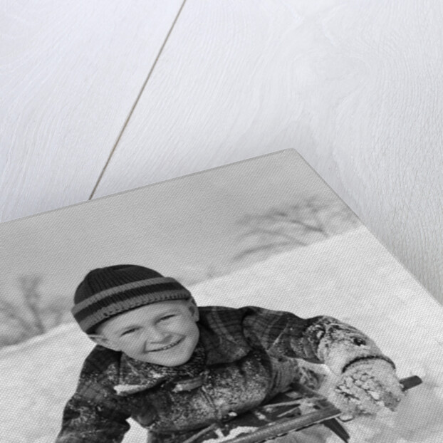 1940s Boy On Sled In Snow Facing Camera Hands And Jacket Covered In Snow by Anonymous