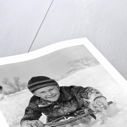 1940s Boy On Sled In Snow Facing Camera Hands And Jacket Covered In Snow by Anonymous