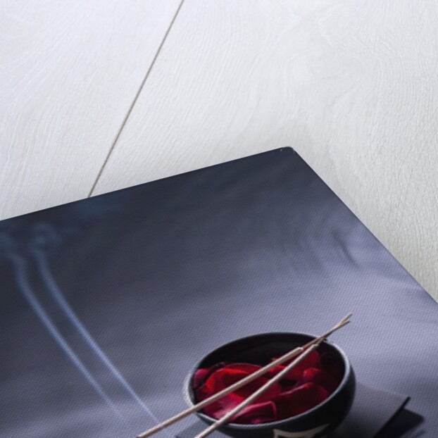 Burning incense on top of bowl of petals by Anonymous