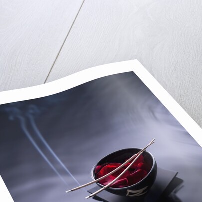 Burning incense on top of bowl of petals by Anonymous