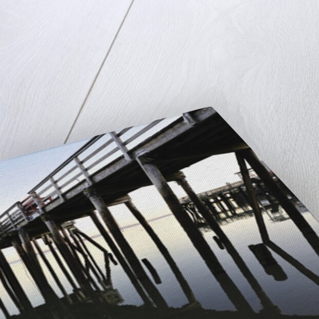 Fishing pier at low tide in a calm bay by Anonymous