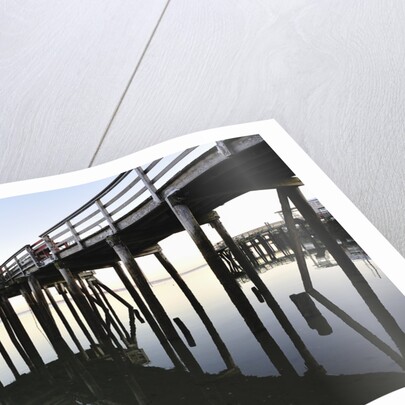 Fishing pier at low tide in a calm bay by Anonymous