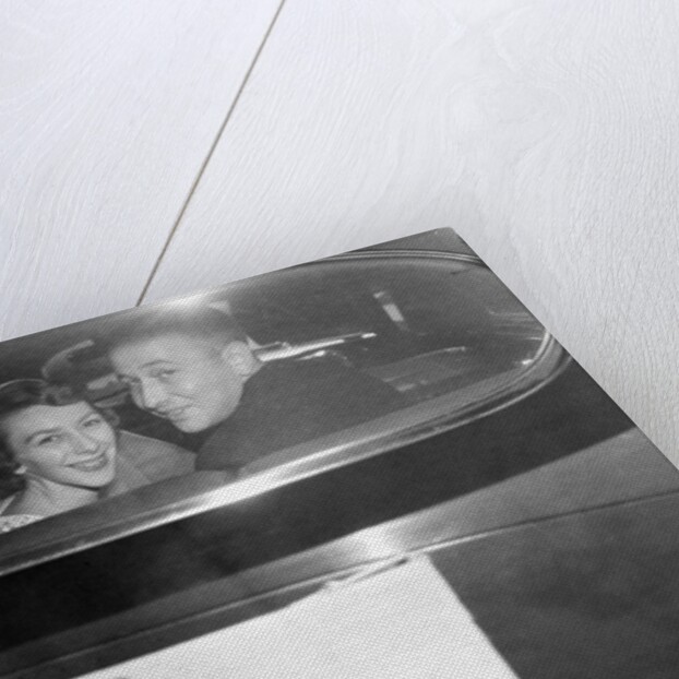A couple peers out of the back window on their wedding day, ca. 1953 by Anonymous