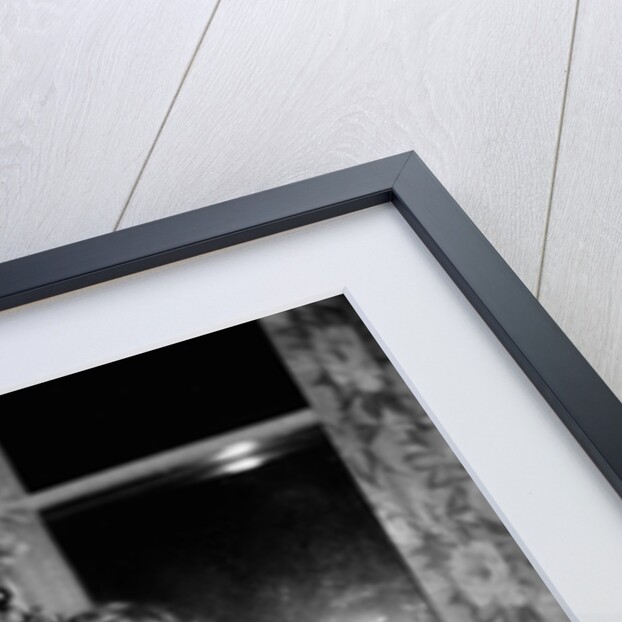 A little girl stands by the Christmas tree clutching her doll, ca. 1955 by Anonymous