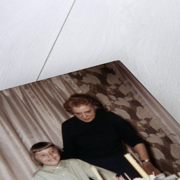 Nine year old girl is about to blow out the candles on her while her mom watches, ca. 1962 by Anonymous