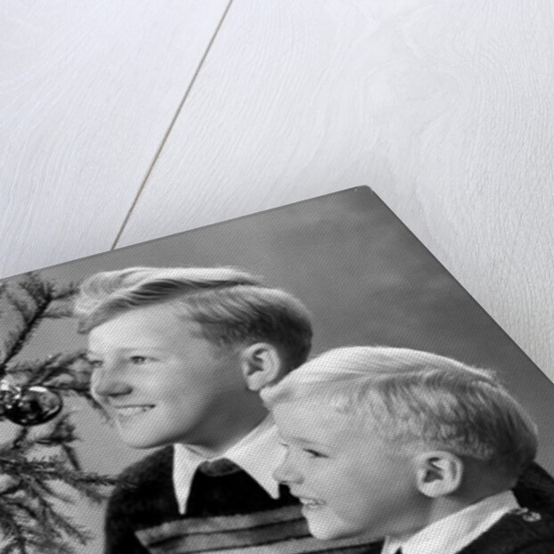 Two brothers look at a candle on a Christmas tree in Germany, ca. 1950 by Anonymous
