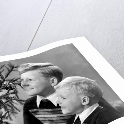 Two brothers look at a candle on a Christmas tree in Germany, ca. 1950 by Anonymous
