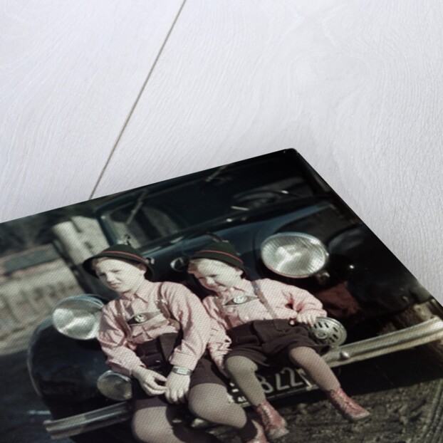Two brothers sit on the bumper of the family Mercedes Benz in Germany, ca. 1949 by Anonymous