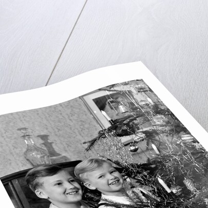Two brothers look at a Christmas tree in their living room in Germany, ca. 1949 by Anonymous