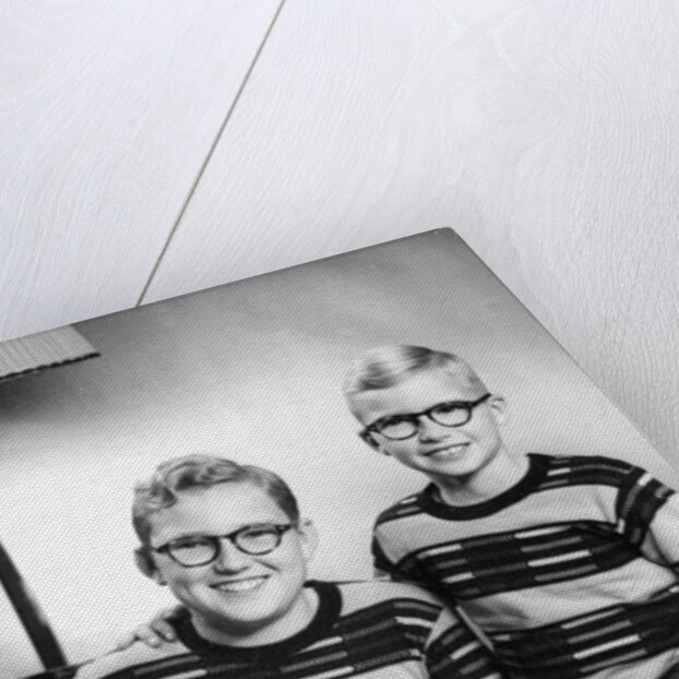 Two brothers pose with a book on their living room couch, ca. 1953 by Anonymous