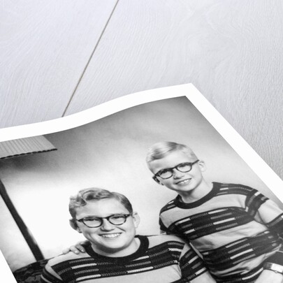 Two brothers pose with a book on their living room couch, ca. 1953 by Anonymous