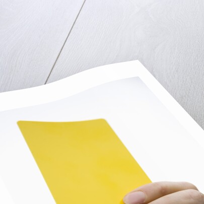 Hand holding yellow card by Anonymous