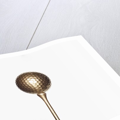 Gold golf ball and tee by Anonymous