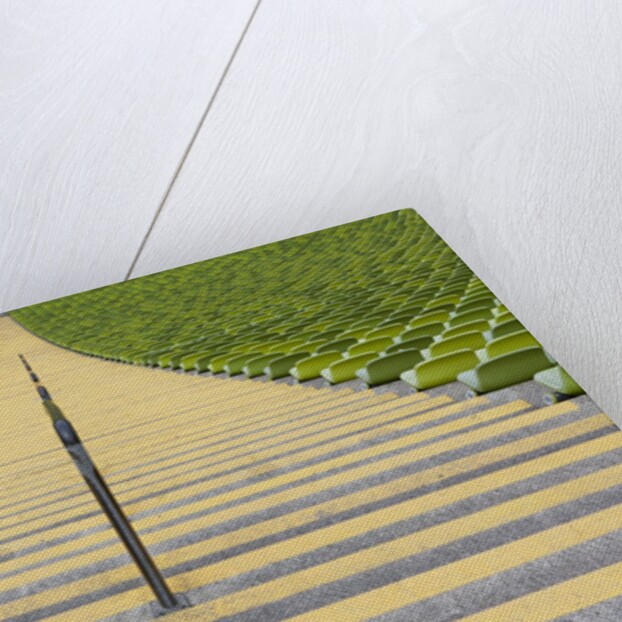Stadium stairway between rows of green seats by Anonymous