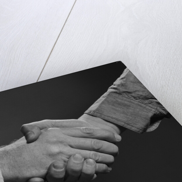 Close-up handshake between businessman and laborer by Anonymous