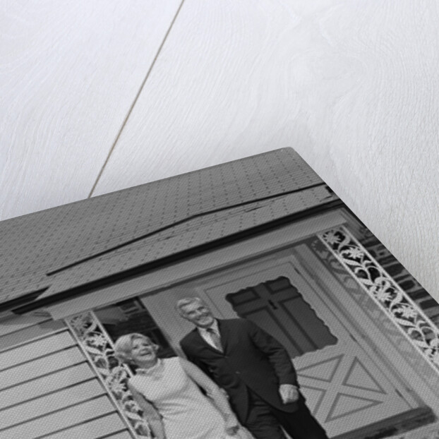 Mature couple walking on sidewalk front of house by Anonymous