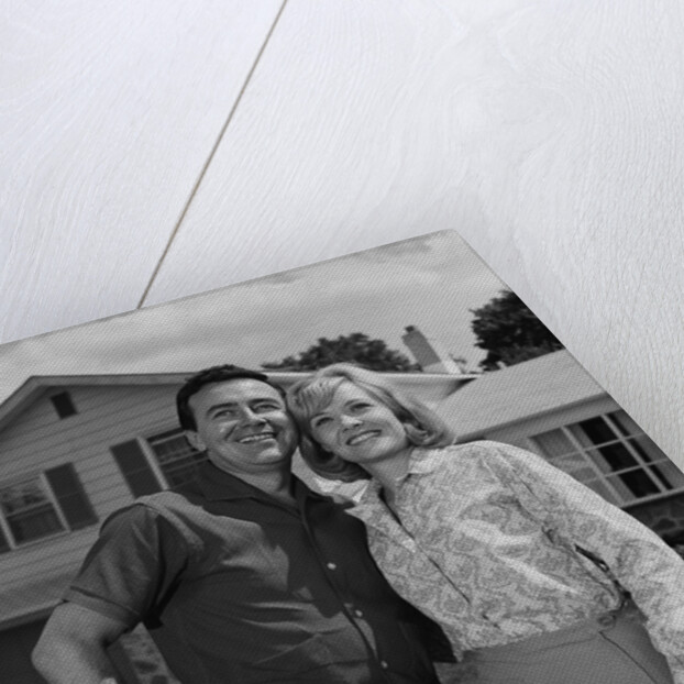 Happy couple portrait man woman smiling in front of home by Anonymous