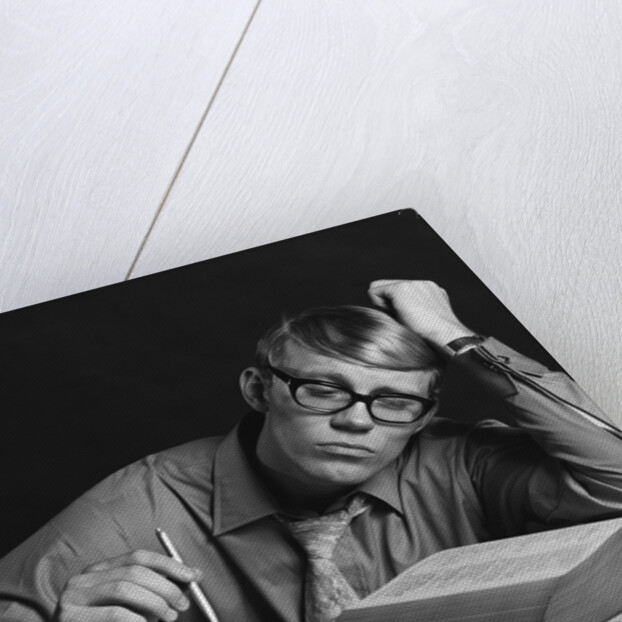 Young man studying reading books leaning on arm by Anonymous