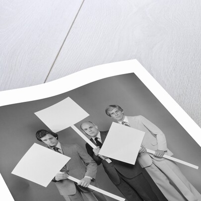 Trio of businessmen carrying blank signs by Anonymous