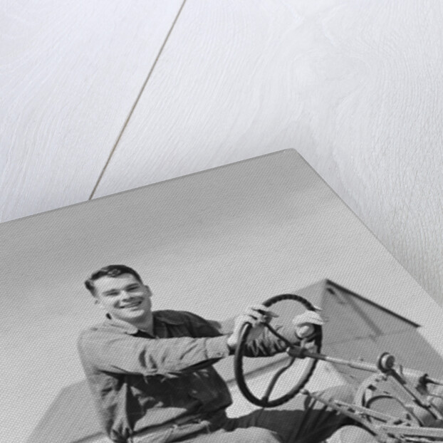 Smiling man farmer driving tractor by Anonymous