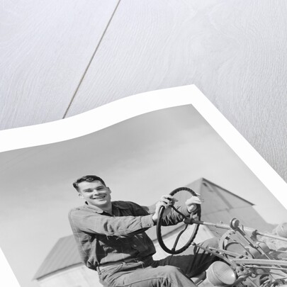 Smiling man farmer driving tractor by Anonymous