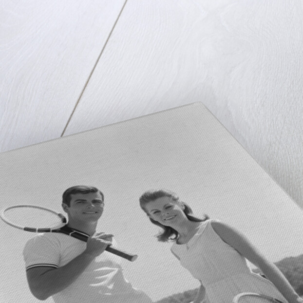 Portrait tennis couple man woman holding racquets standing by net by Anonymous