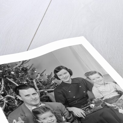Family portrait by christmas tree by Anonymous
