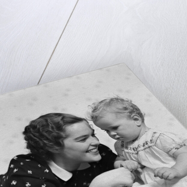Woman mother smiling sitting playing with baby daughter by Anonymous